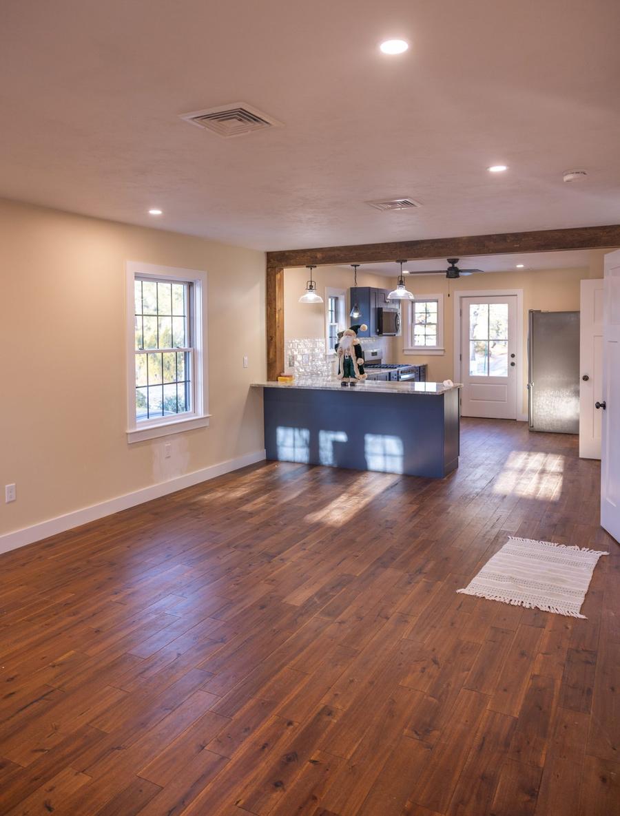 Open-concept kitchen and living room remodel with hardwood floors and exposed reclaimed beam — Perocchi Building & Remodeling