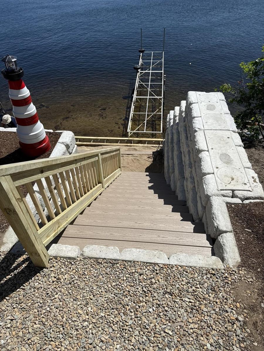 Waterfront composite deck and stairway with granite retaining wall built by Perocchi Building & Remodeling, Cape Cod MA
